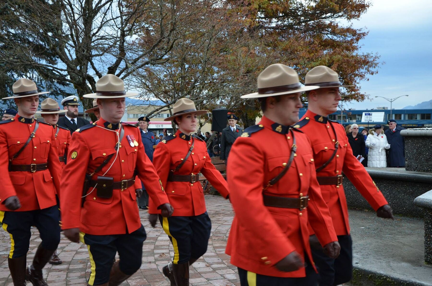 RCMP officers in red serge march in the Remembrance Day parade